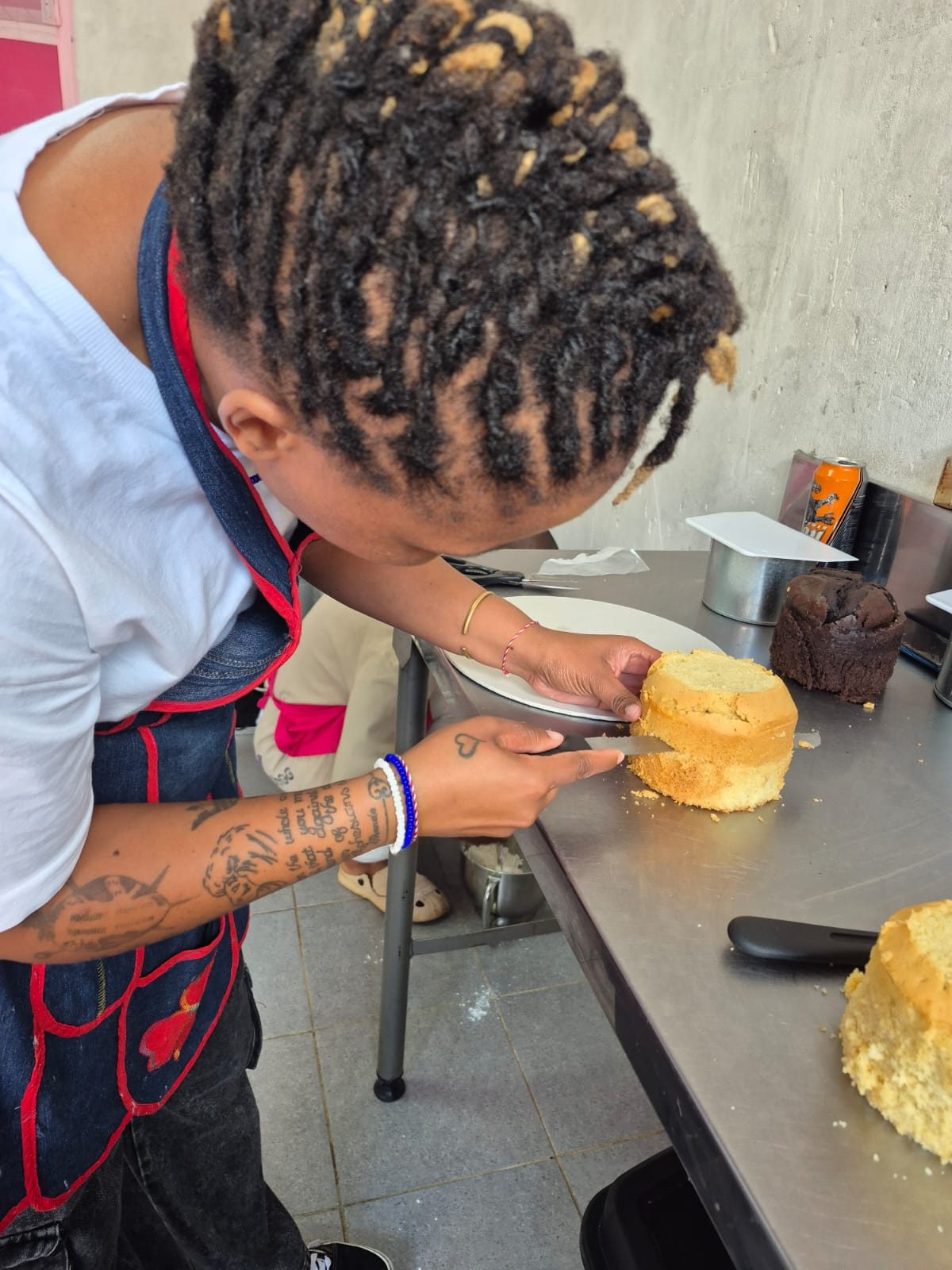 A student levelling a freshly baked sponge cake during a Rosy's Cakes and Events class